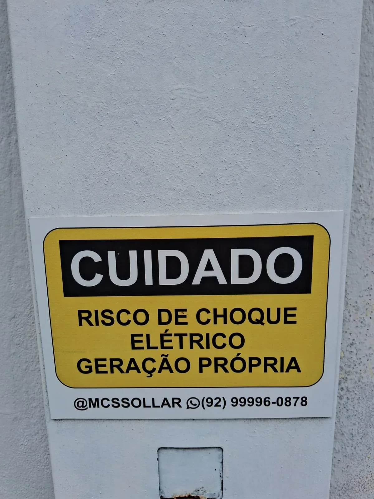 Placa com alerta de risco de choque elétrico em geração própria.