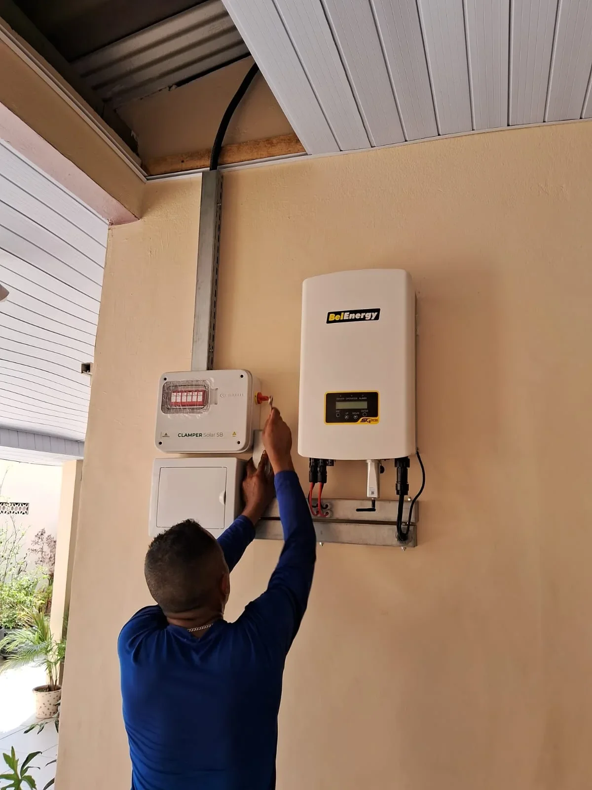 Profissional realiza uma atividade junto a um inversor e componentes de proteção.